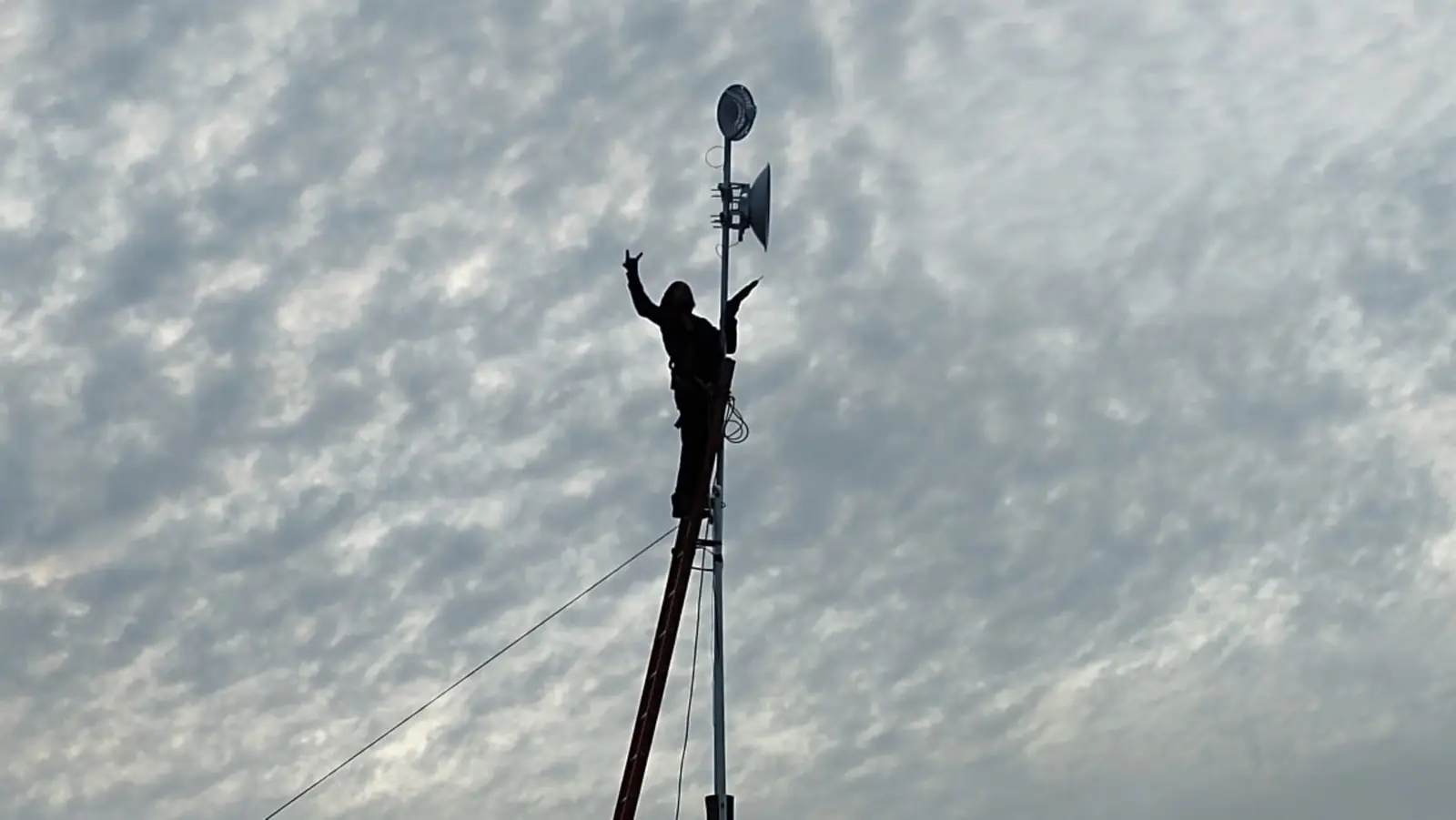 Técnico de nora instalando una antena al atardecer en el corredor costero del Maule